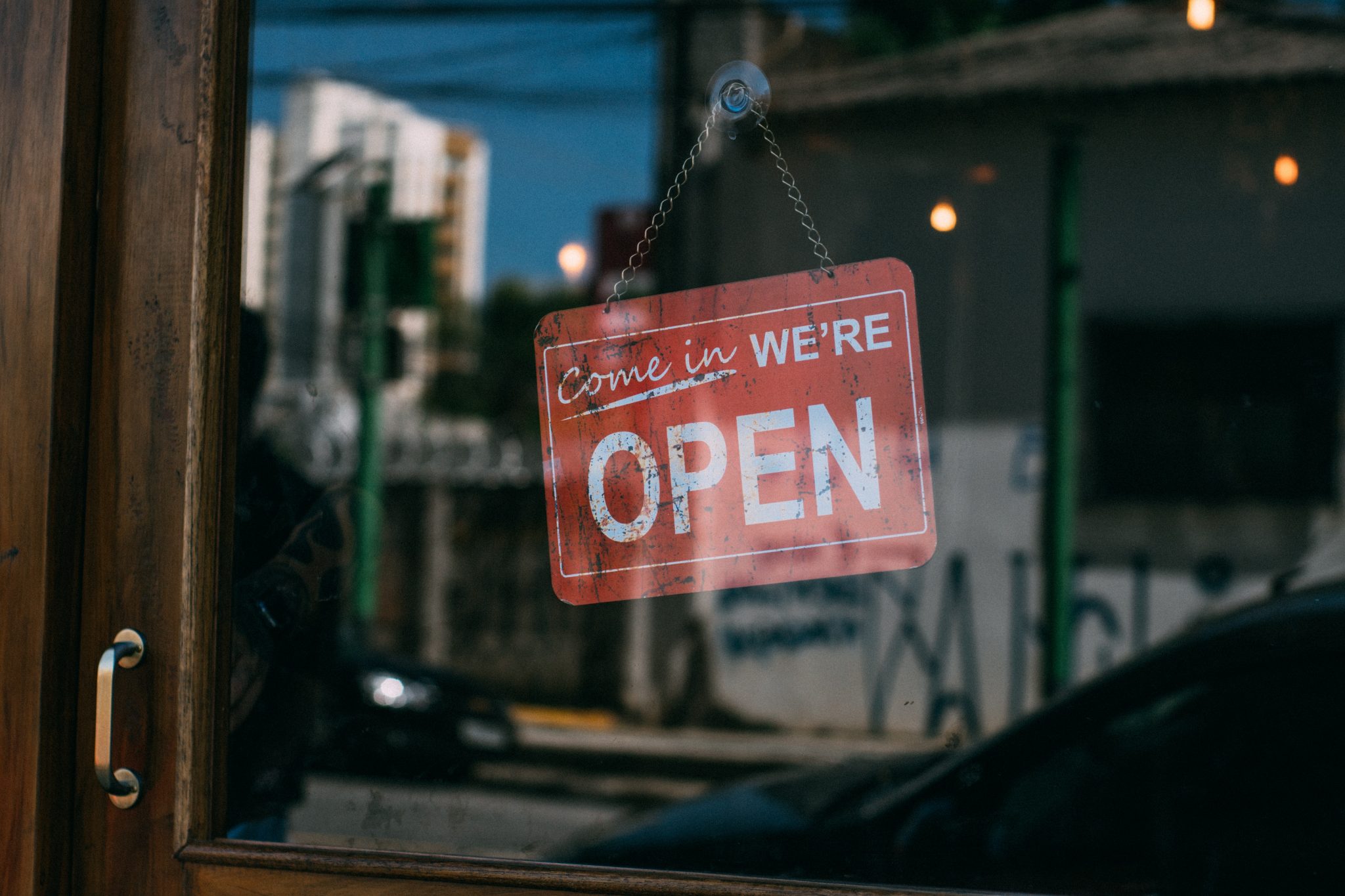 We're Open sign hanging in business doorway