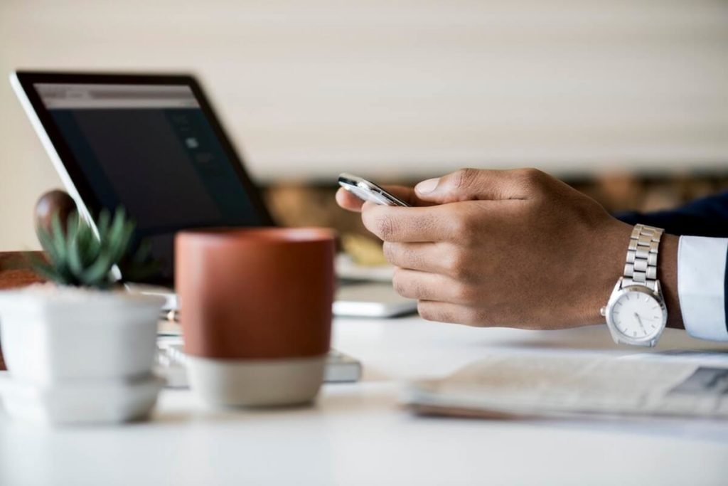 Business person using a mobile phone and laptop