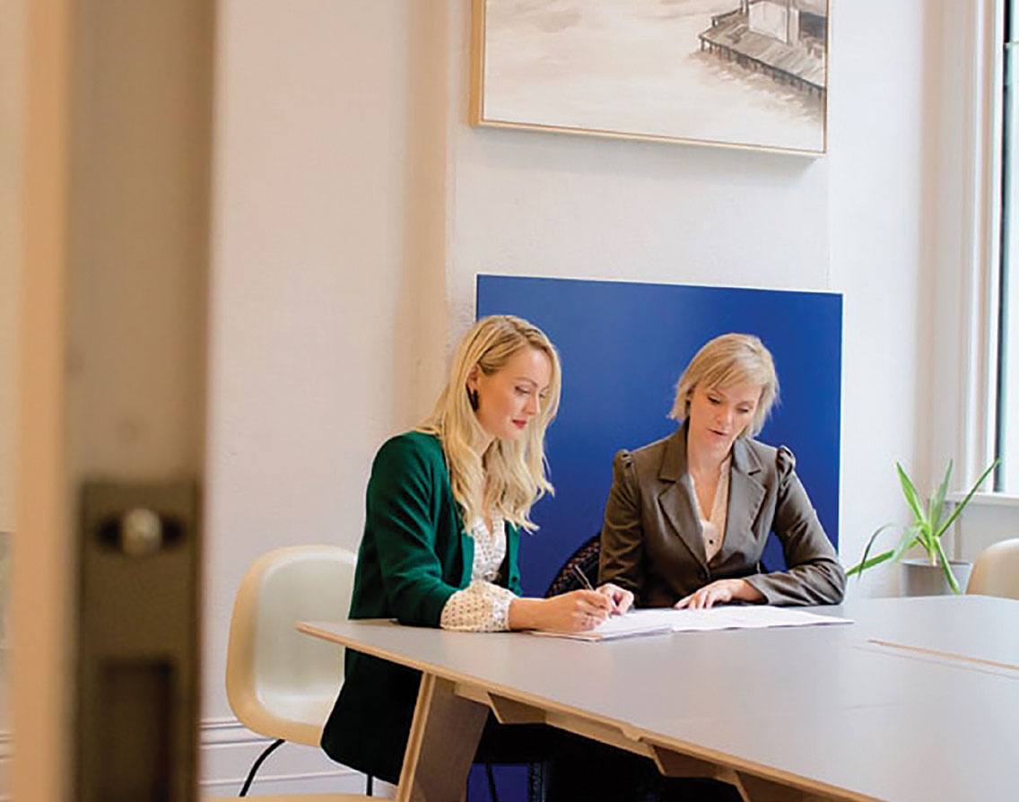 Two professional business women reading documents