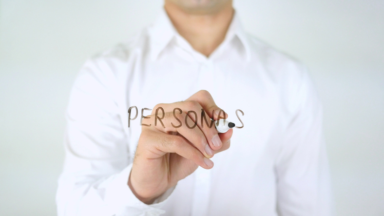 Man writing the word Personas on glass