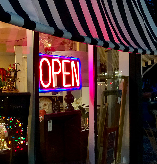 A glowing neon OPEN sign in a storefront window