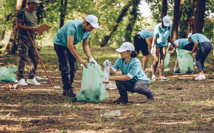Group of people, cleaning together in public park, saving the environment.