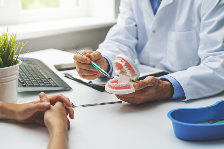 Dentist and patient discussion about planned teeth treatment in dental clinic office