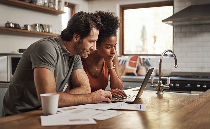 A young couple studying a laptop computer