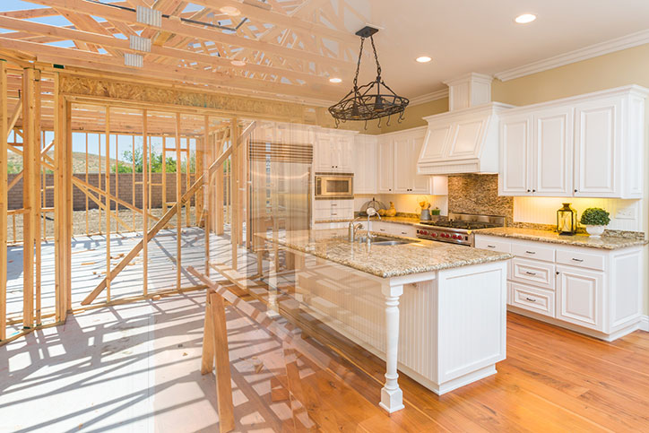 Rough kitchen construction image fading to a finished kitchen remodel